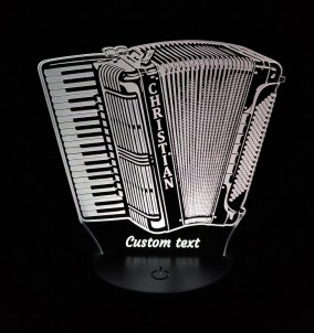 Personalizirana 3D LED svetilka v obliki klavirske harmonike, ki sveti v beli barvi, stoji na nočni omarici.